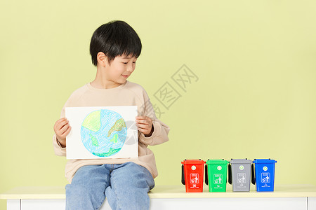 纸分类和素材小男孩抱着手绘地球画看着垃圾分类桶背景