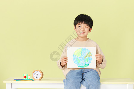 儿童绘本馆小男孩抱着手绘地球微笑背景