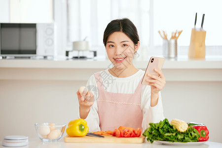 使用手机查看菜谱的年轻女性背景