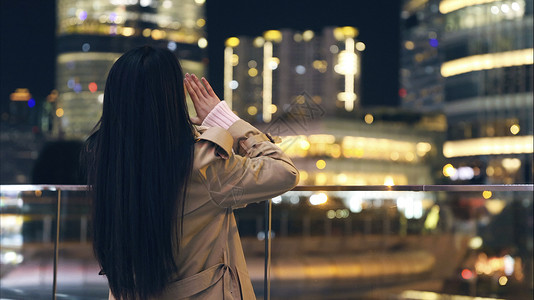 夜晚城市人年轻美女对着城市呐喊背影背景