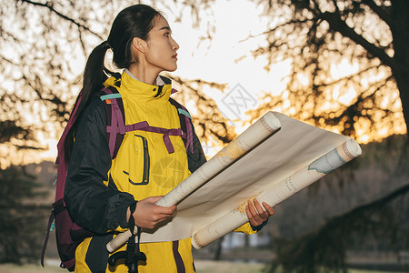 黄色世界地图女生户外徒步登山手拿地图形象背景