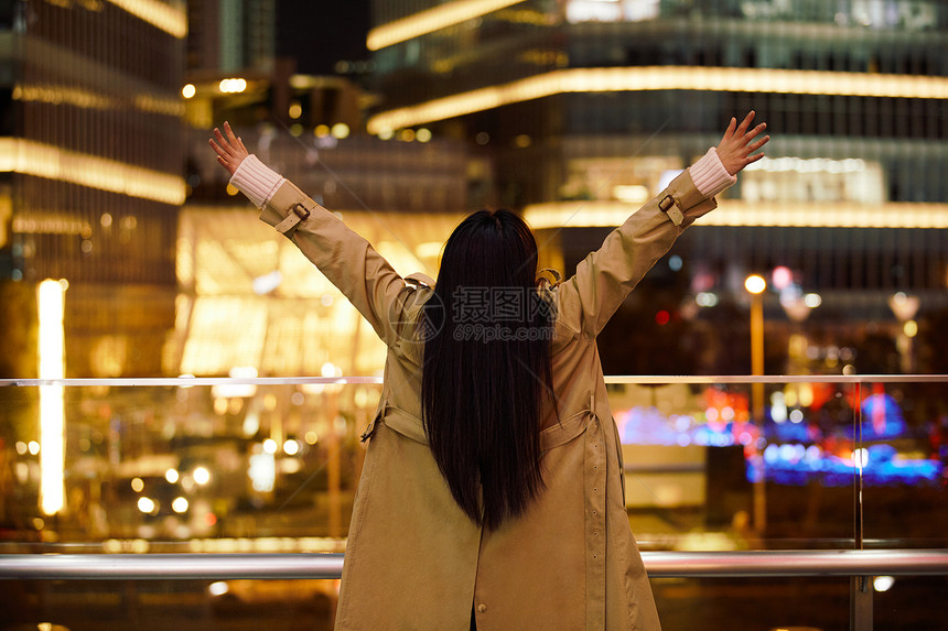 冬季夜晚都市女性人像双手举起欢呼图片