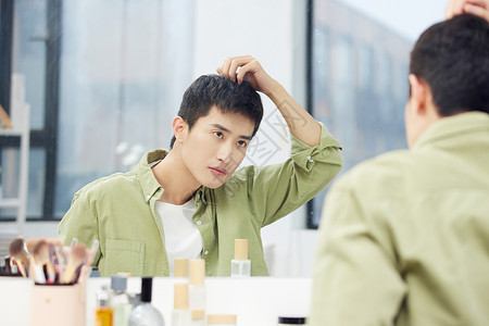 年轻男士镜子前整理发型高清图片