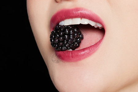 女性吃树莓嘴部特写图片