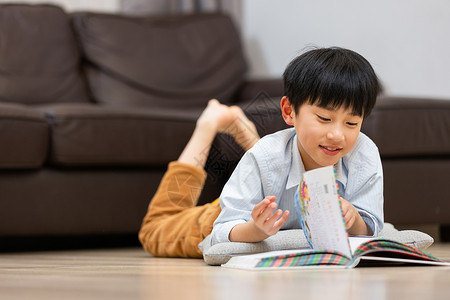 小男孩趴在客厅读书图片