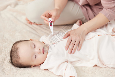 用体温计帮新生儿宝宝测量体温关爱高清图片素材