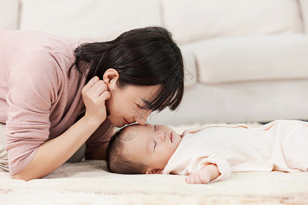 女性亲吻睡着的小宝宝高清图片