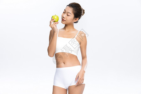 肌肉纤维塑形塑身美女手拿苹果饮食管理背景