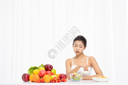 厌倦吃水果沙拉的年轻女孩图片
