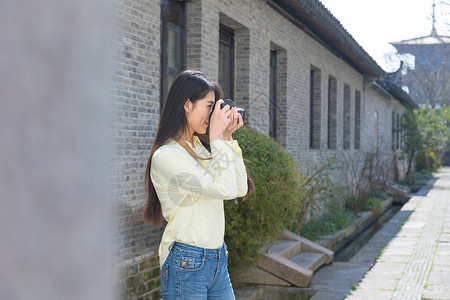 美女背着相机一个人旅行拍照背景图片