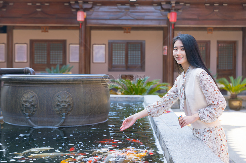 美女大学生逛寺庙喂食金鱼图片