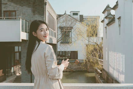 青春美女大学生背着相机旅行拍照图片