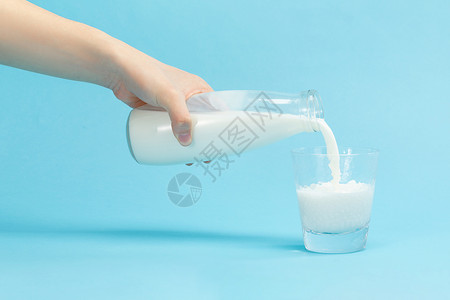 向杯子里倒牛奶特写背景图片