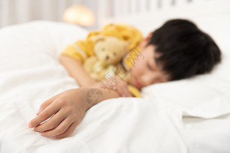 儿童小熊杯抱着小熊睡着的小男孩手部特写背景