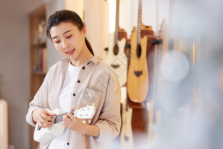 音乐培训班招生弹奏尤克里里的女性背景