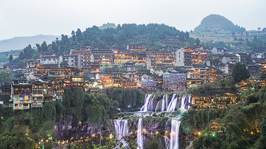 湖南湘西挂在瀑布上的芙蓉古镇夜景高清图片素材