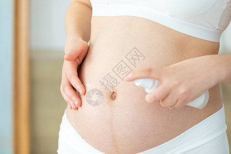 衣服上乳液孕妇在肚子上涂护肤品背景