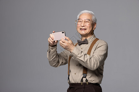 使用手机拍照的老人背景图片