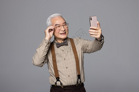 使用手机自拍的老人背景图片