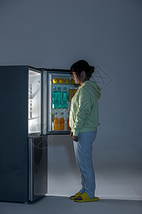 晚上在冰箱前面偷吃的女性背景图片