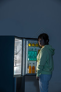 晚上在冰箱前面偷吃的女性背景图片