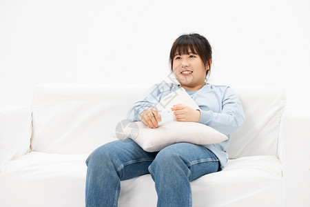 慵懒躺在沙发上开心的肥胖女性高清图片