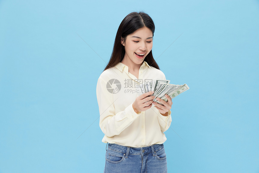 手拿现金的年轻女性图片