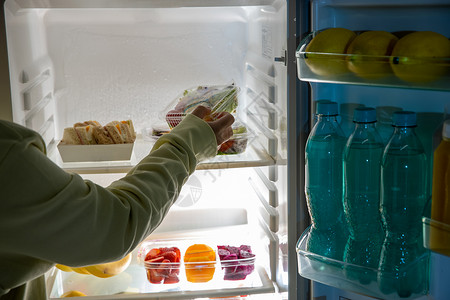 冰箱里的食物从冰箱里拿出食物的手背景