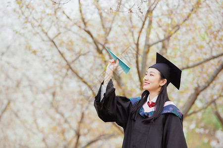 毕业梦想女大学生公园毕业照扔纸飞机背景