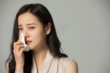 哭泣悲伤的女性用纸巾擦泪水图片