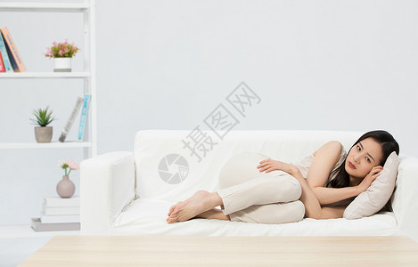 悲伤难过的女性躺在沙发图片