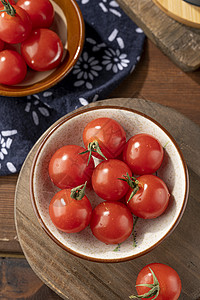 木桌上小碟里的樱桃番茄高清图片