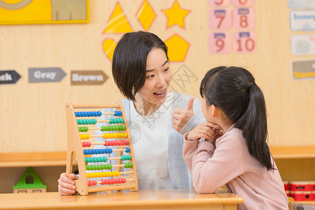 学生表扬素材幼儿园老师和小女孩玩玩具背景