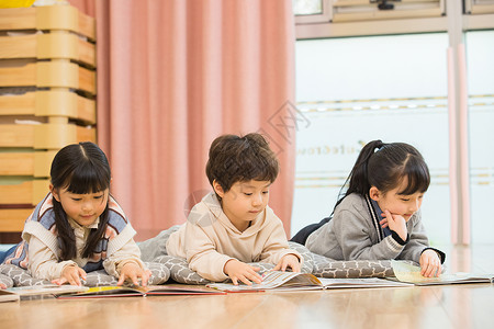 小朋友们趴在地上看书背景图片