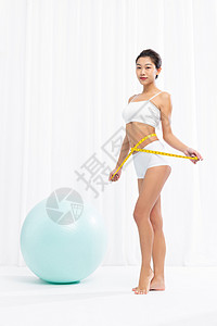美女用瑜伽球做瑜伽背景图片