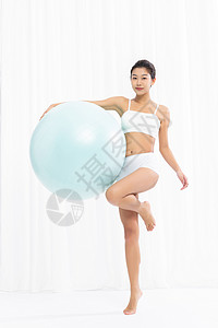 美女用瑜伽球做瑜伽背景图片
