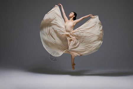 美女舞者跳跃舞动长裙裙摆背景图片