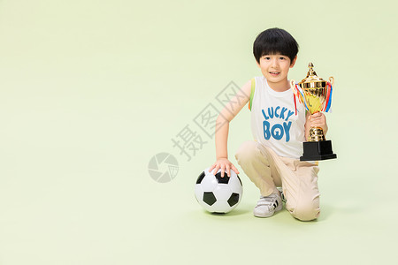 小男孩踢足球得奖杯背景图片