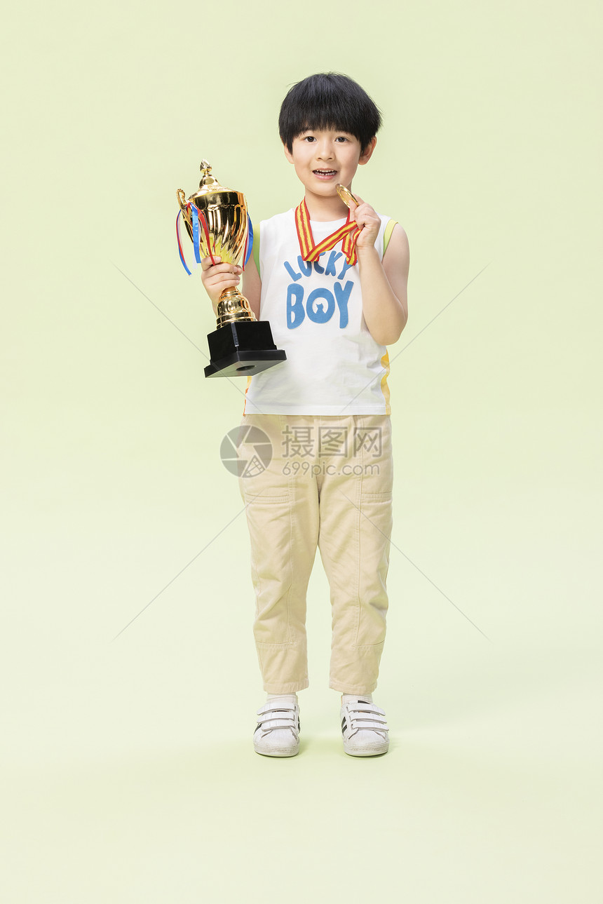小男孩手捧奖杯金牌图片