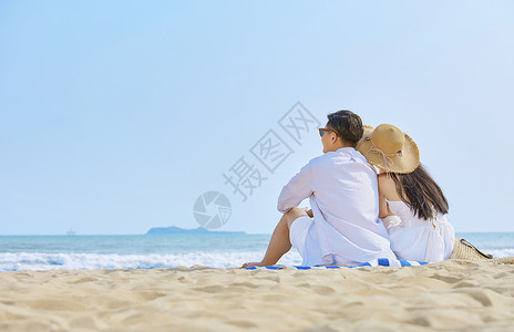 夏季风情侣海边情侣坐在沙滩看大海背影背景