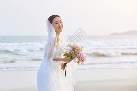 海边婚纱照海边穿婚纱的美女手拿手捧花背景