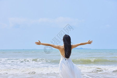 女人的欢呼夏日海边美女张开手臂背影背景
