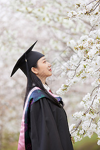 撑船赏荷的女孩学士服美女春季赏樱花背景