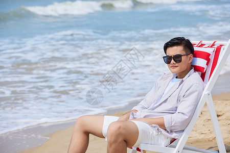 沙滩上休息人年轻男生海边度假沙滩椅上休息背景