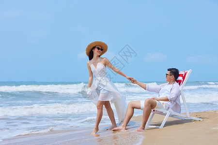 女性夏日沙滩椅看书年轻情侣海边度假互动背景