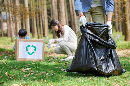 保护环境标志一家三口公园里捡拾垃圾背景