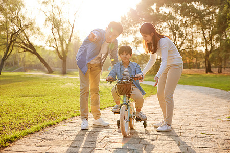 父亲骑车带小孩父母教儿子骑自行车背景