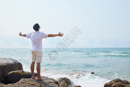 夏季男孩背影男青年张开手臂拥抱大海背影背景