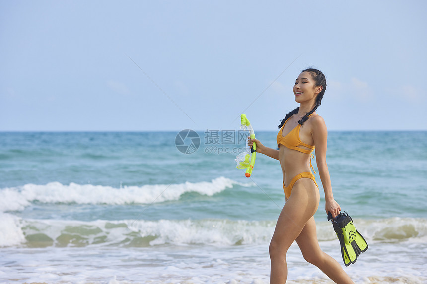 比基尼美女在海边拿着潜水装备图片