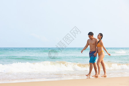 年轻情侣海边牵手散步高清图片